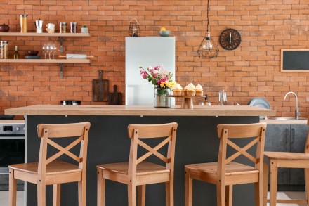 Wyspa kuchenna lub barek z krzesłami nadaje pomieszczeniu przytulny charakter